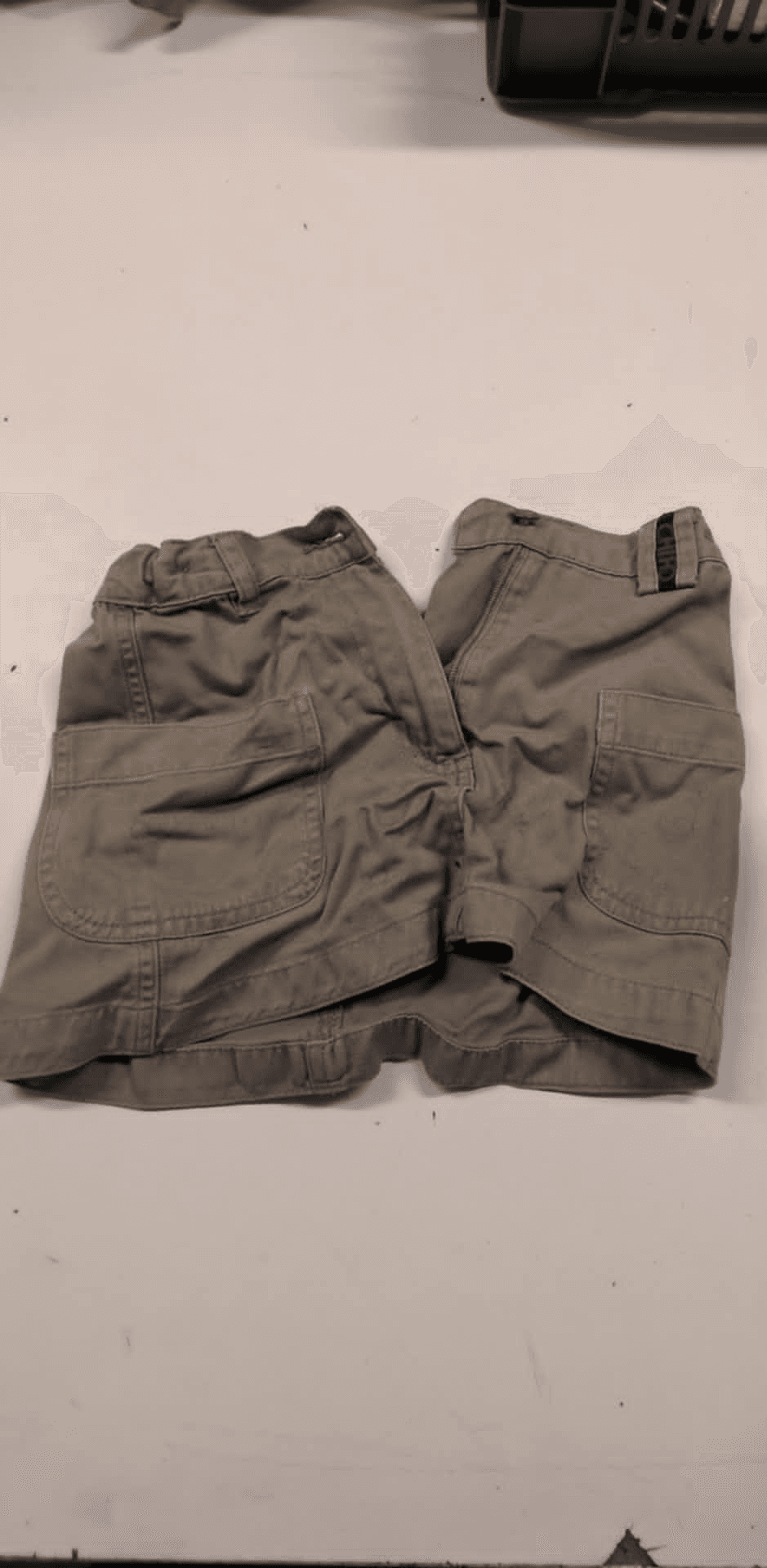 a pair of khaki shorts laying on a white surface