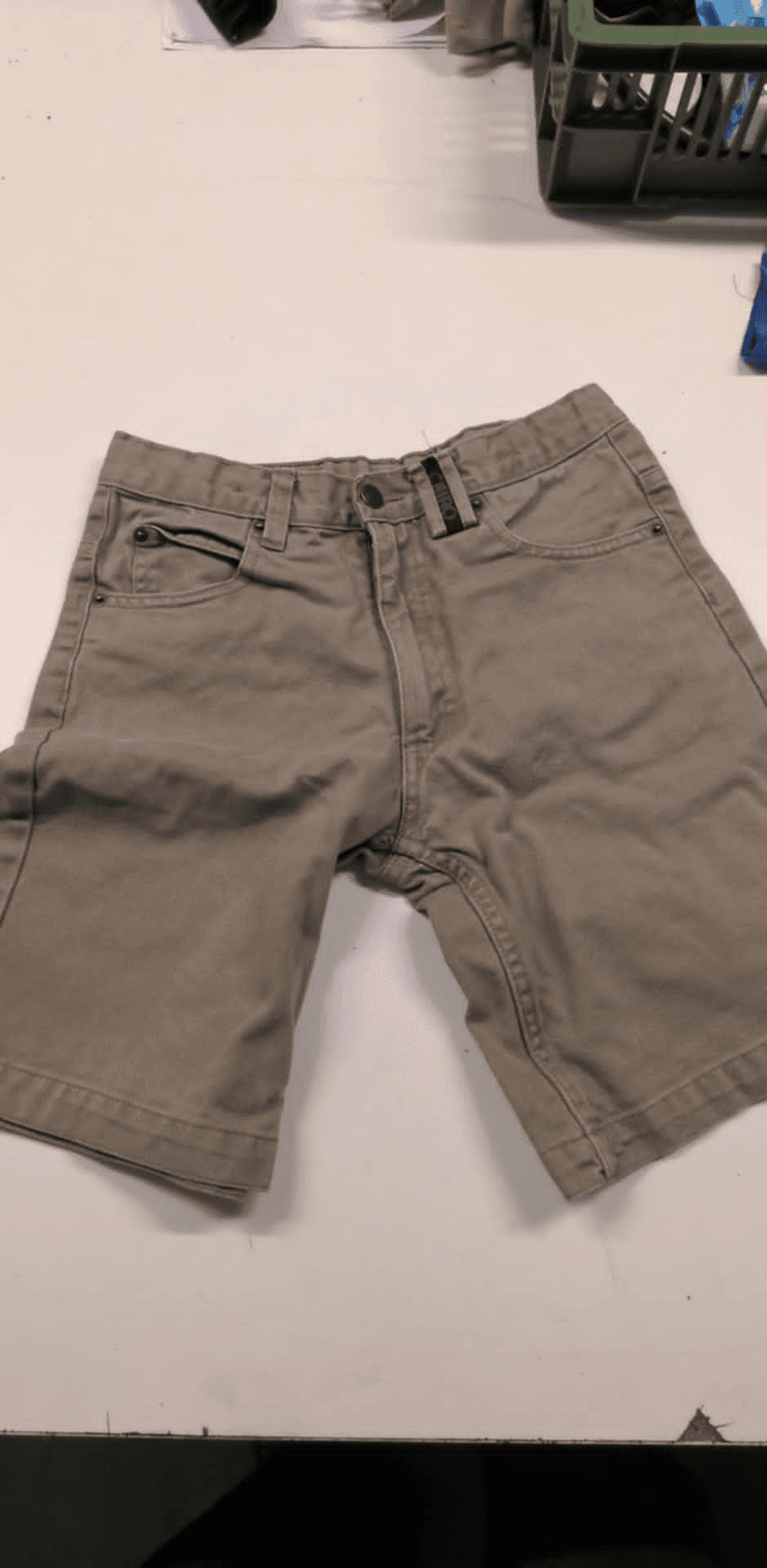 a pair of khaki shorts on a white table