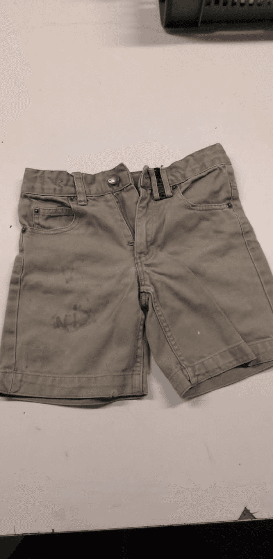 a pair of khaki shorts on a white surface